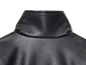 Close-up of the black faux leather jacket texture with detailed collar and shoulder seams