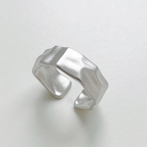 Detail showing irregular hammered texture and matte finish on the silver open ring