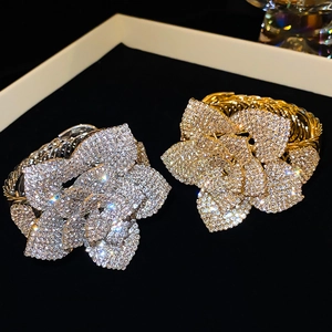 Close-up of adjustable silver and gold flower bracelets with sparkling rhinestones