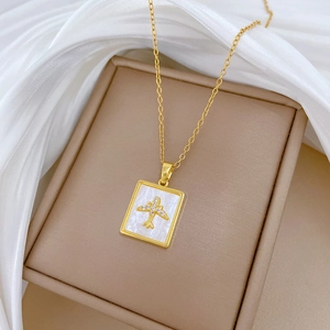 Detailed shot of gold-plated titanium necklace with aircraft shell pendant on beige box