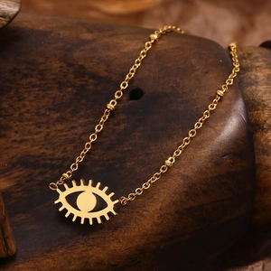 18K gold plated stainless steel necklace with a mini turquoise evil eye pendant on wood