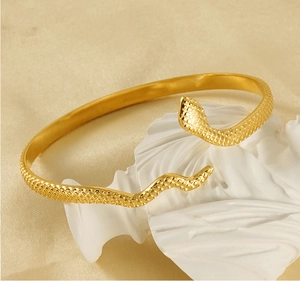Detailed view of the 18k gold snake-shaped bangle with engraved scale texture