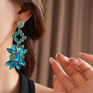 Détails des boucles d'oreilles vintage en losange avec fleurs et pompons de cristal bleu