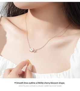 Macro detail of rose gold cherry blossom pendant with sparkling zircons and mother of pearl