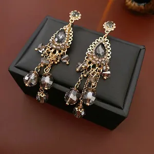 Retro bohemian tassel drop earrings with crystals and gold finish on leather