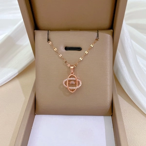 Close-up of rose gold necklace with interlocking diamond pendants in a beige jewelry box
