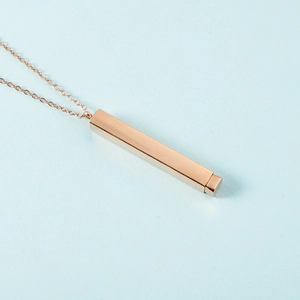 Detailopname van de roségouden roestvrijstalen staafketting op lichtblauwe achtergrond