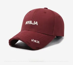 Detailed side view of dark red baseball cap with white embroidery and distressed brim