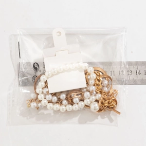 Detailed view of baroque pearl and gold chain bracelet measured with a steel ruler