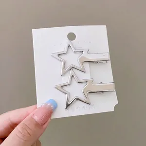 Détail de pinces à cheveux étoiles argentées sur carte avec mesure de 5,2 cm
