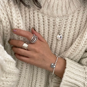 Vintage 925 sterling silver ring set and heart bracelet on white knit sweater