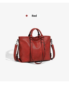 Detailed view of red textured leather tote bag with dark hardware and detachable strap
