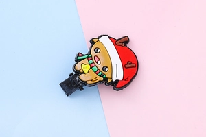 Close-up of a festive cartoon reindeer hair clip with a red hat and scarf for children
