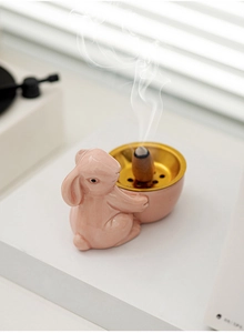 Detailed close-up of pink ceramic bunny incense burner with smoke effect and gold tray