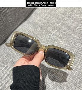 Detail view of translucent olive green square sunglasses with silver rivets and grey lenses
