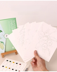 Detail of thick watercolor paper kit with floral sketches, pigments and water brush