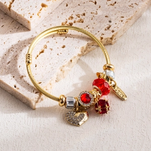 Golden wire twist bracelet with red crystal beads and a sparkling heart pendant