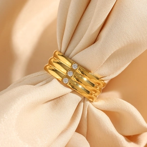 Macro shot of 18K gold plated ring with triple wavy bands and vertical zircon stones