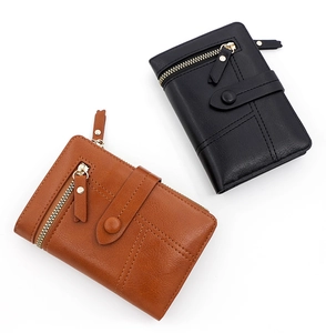 Close-up of brown and black PU leather wallets with buckle zipper and fine stitching