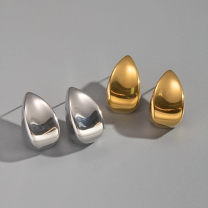 Détail de boucles d'oreilles goutte évidées en finitions or et argent polies