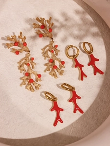 Macro detail of red coral charms and 18k gold plated stainless steel hoop earrings