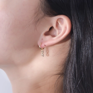 Close-up of gold 925 silver infinity drop earrings with zircon paving on model