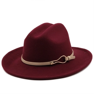 Detail of burgundy wool fedora with a beige leather strap and gold metallic buckle