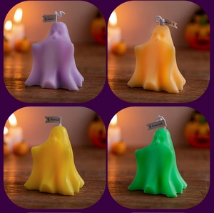 Close-up of four colorful ghost-shaped scented candles in purple orange yellow and green