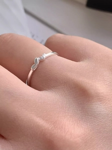 Close-up of S925 silver heart ring with sparkling zircon stone on a woman finger