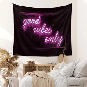 Detail of bohemian black wall tapestry featuring neon pink Good Vibes Only text art