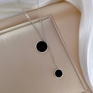 Detailed view of silver titanium steel necklace featuring double black circular pendants
