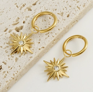 Detail view of 18K gold plated sunflower earrings with sparkling starburst zircon charm