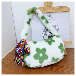 Detail of white plush shoulder bag with green flower patterns and a decorative colorful scarf