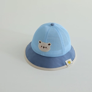 Close-up of breathable mesh fabric and cartoon bear patch on children's sun hat