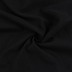 Détail de la texture du tissu noir et du drapé fluide de la robe longue sexy