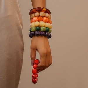 Close-up of stacked colorful acrylic beaded bracelets with irregular square shapes