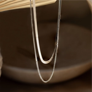 Detail of silver double layered herringbone and box chain necklace in stainless steel