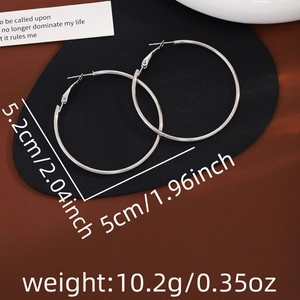 Macro shot of large silver hoop earrings showing 5.2cm diameter and weight detail