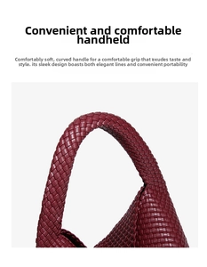 Macro view of burgundy hand-woven leather texture and curved handle of the shoulder bag