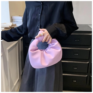 Close-up of lilac ruched cloud bag with stylish knot handle detail held by model