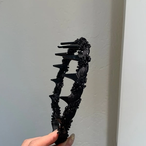 Detail of a black mesh headband featuring sparkling beads and punk style spikes