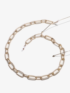 Detail of gold aluminum eyewear chain with textured oval links and silicone loops
