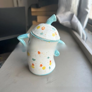 Detailed shot of unique storage jar with hand-painted spots and side handles