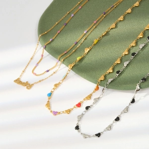 Close-up of gold necklaces with colorful enamel heart charms and Lucky pendants on stand