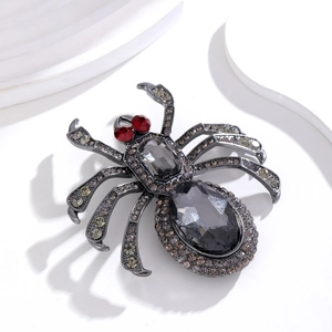 Gothic Spinne Brosche mit rosa und grauen Kristallen in dunkler Legierung auf weißem Grund