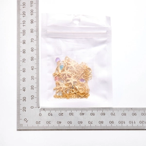 Close-up of golden starfish necklace with colorful beads next to a measuring ruler