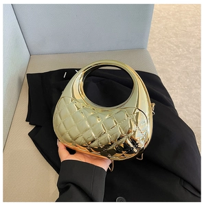 Detail view of metallic gold clutch bag featuring a modern diamond quilted texture design