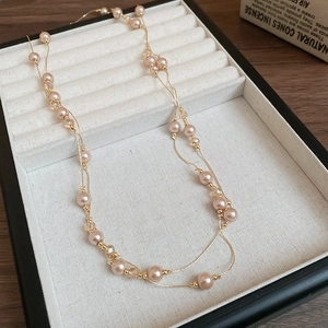 Détails de perles de champagne et perles de cristal sur une fine chaîne dorée