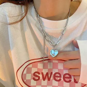 Gros plan sur le collier cœur argenté avec un design unique de chaîne à double couche