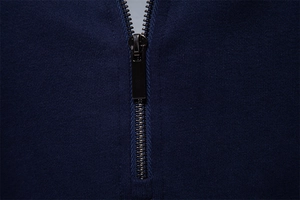 Close-up of the metal zipper detail and dark blue knit fabric on a men's sports sweatshirt